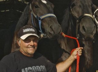 Terry Thompson stands with some of his award-winning Percheron horses on his farm near Zanesville, Ohio. Thompson freed dozens of exotic animals he owned, then killed himself Tuesday, officials say.